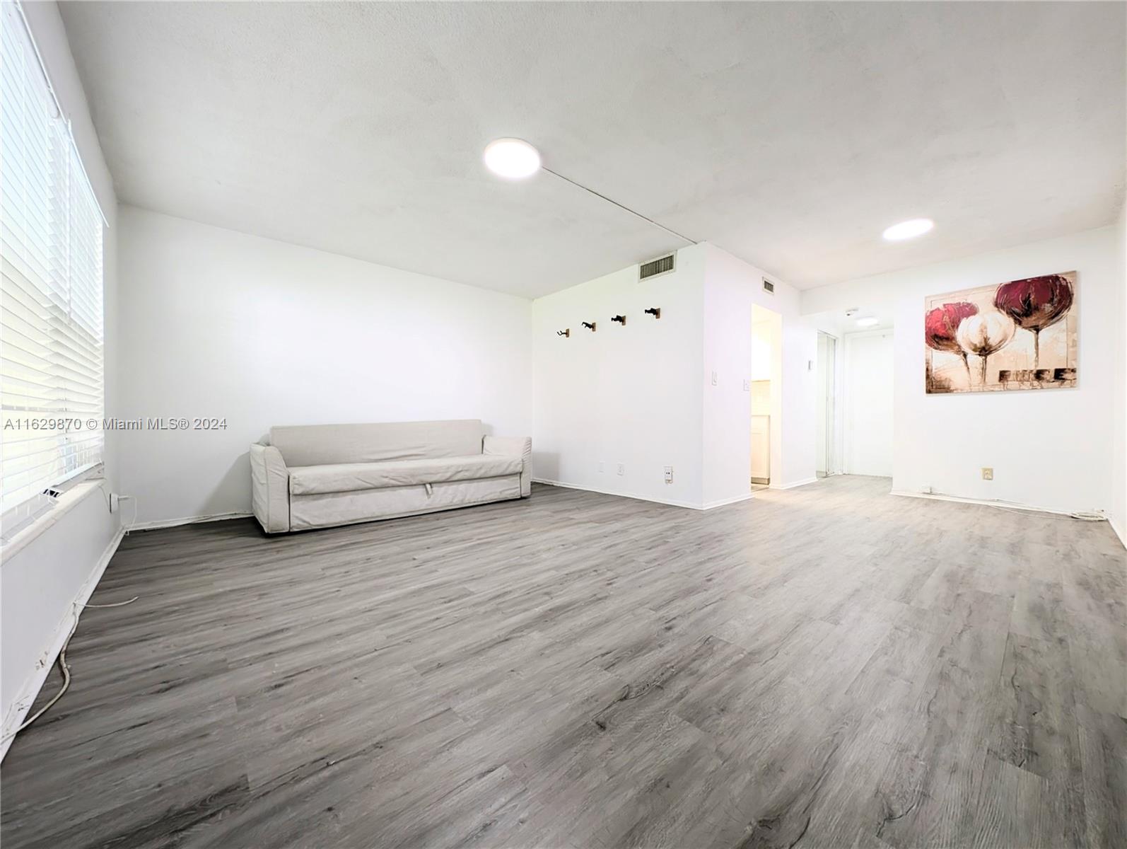 wooden floor with white walls and windows