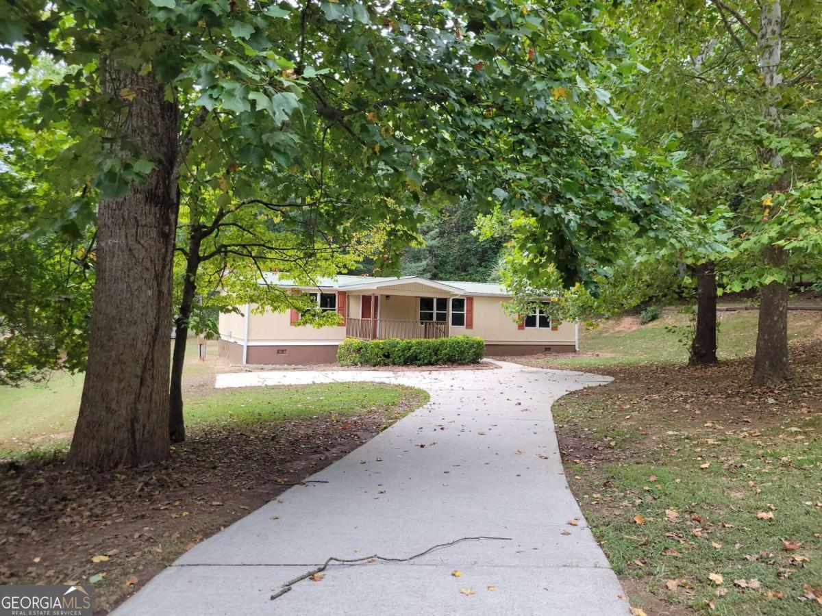 a front view of a house with a yard and trees