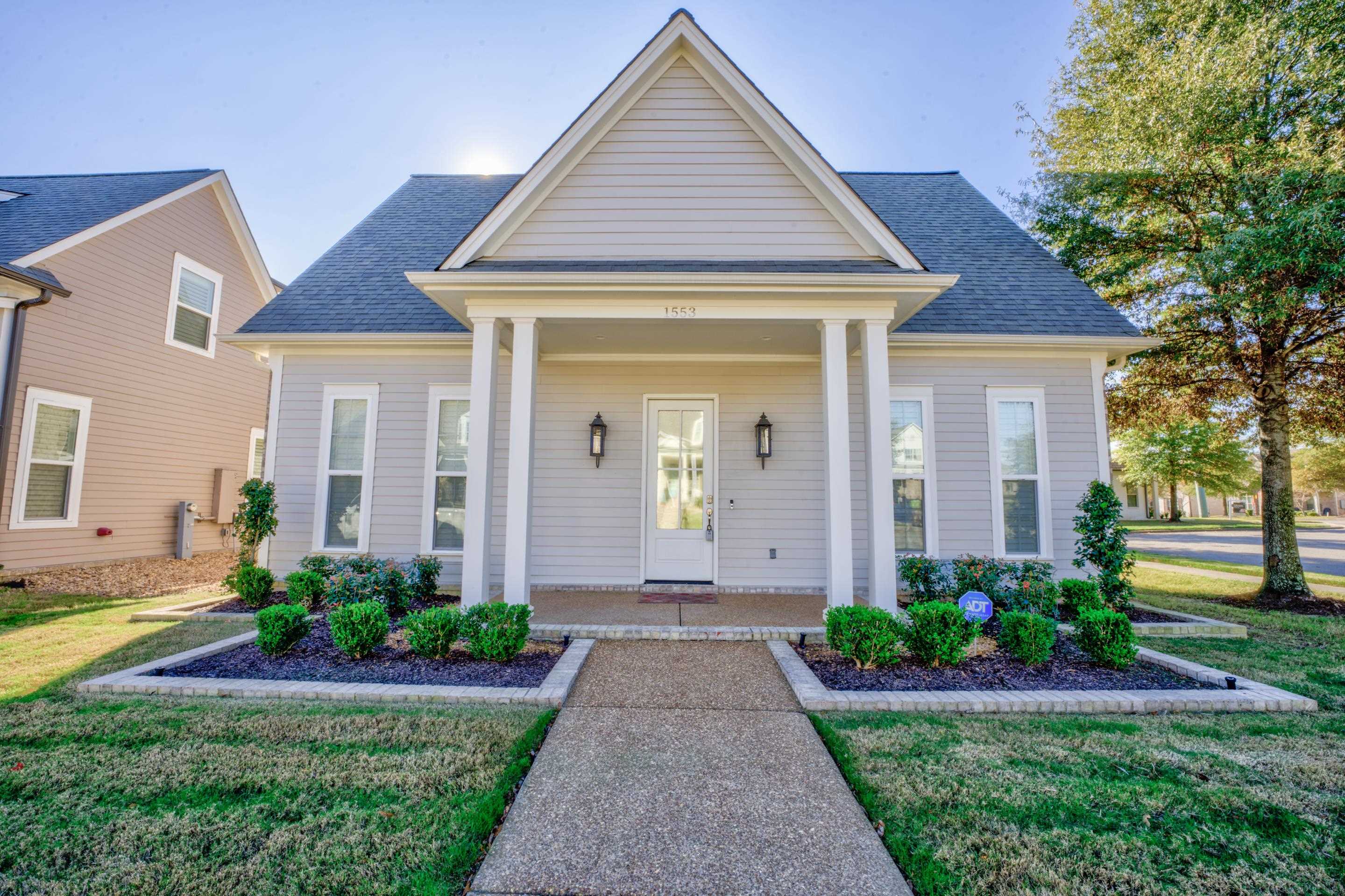 View of front of home featuring covered porch and a front lawn