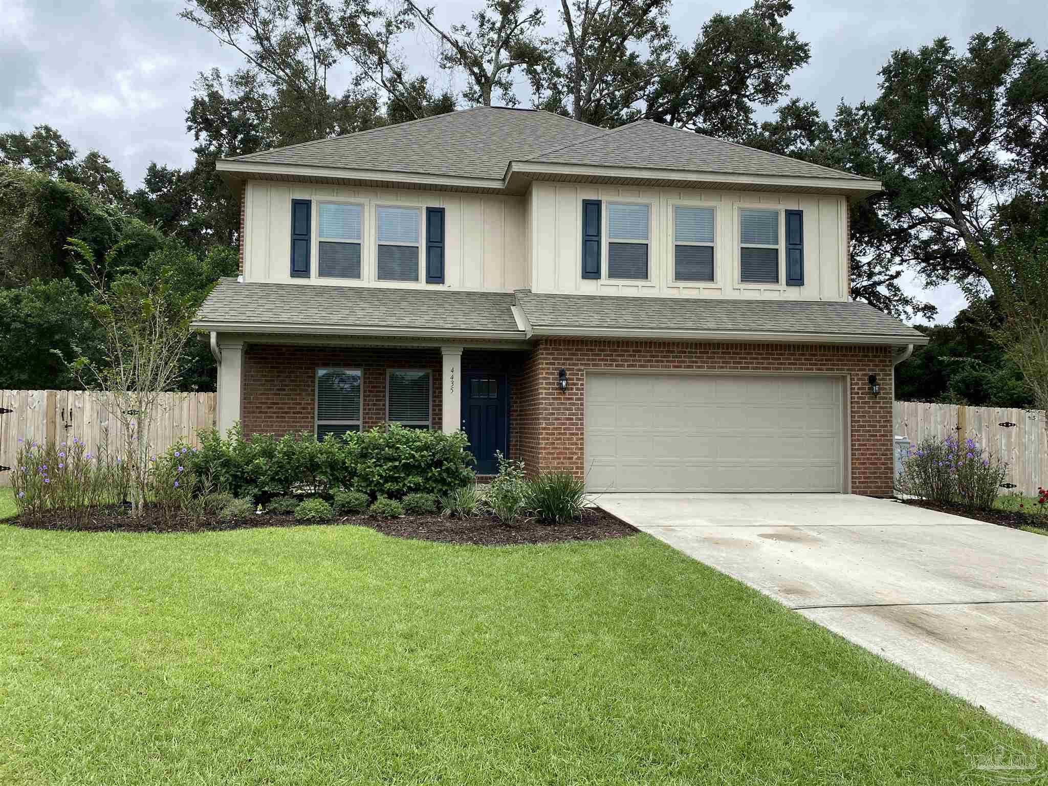 a front view of a house with a garden and yard