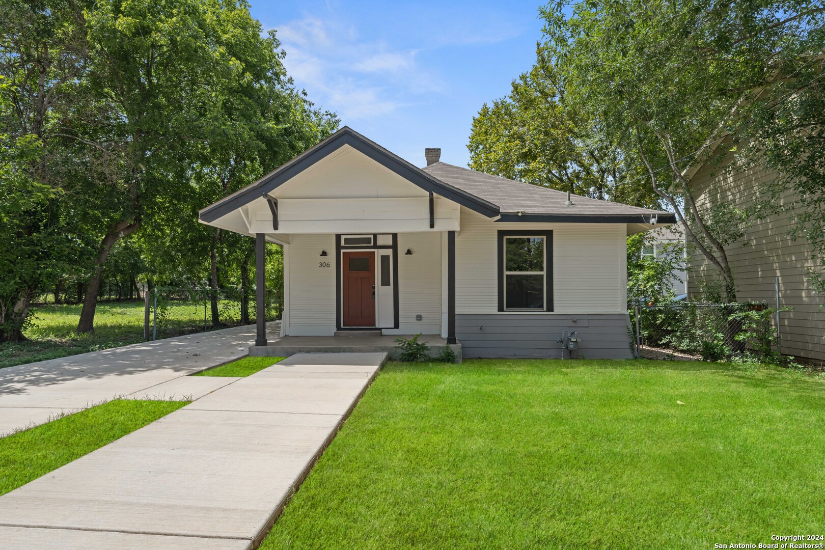 a view of a house with a yard and tree s