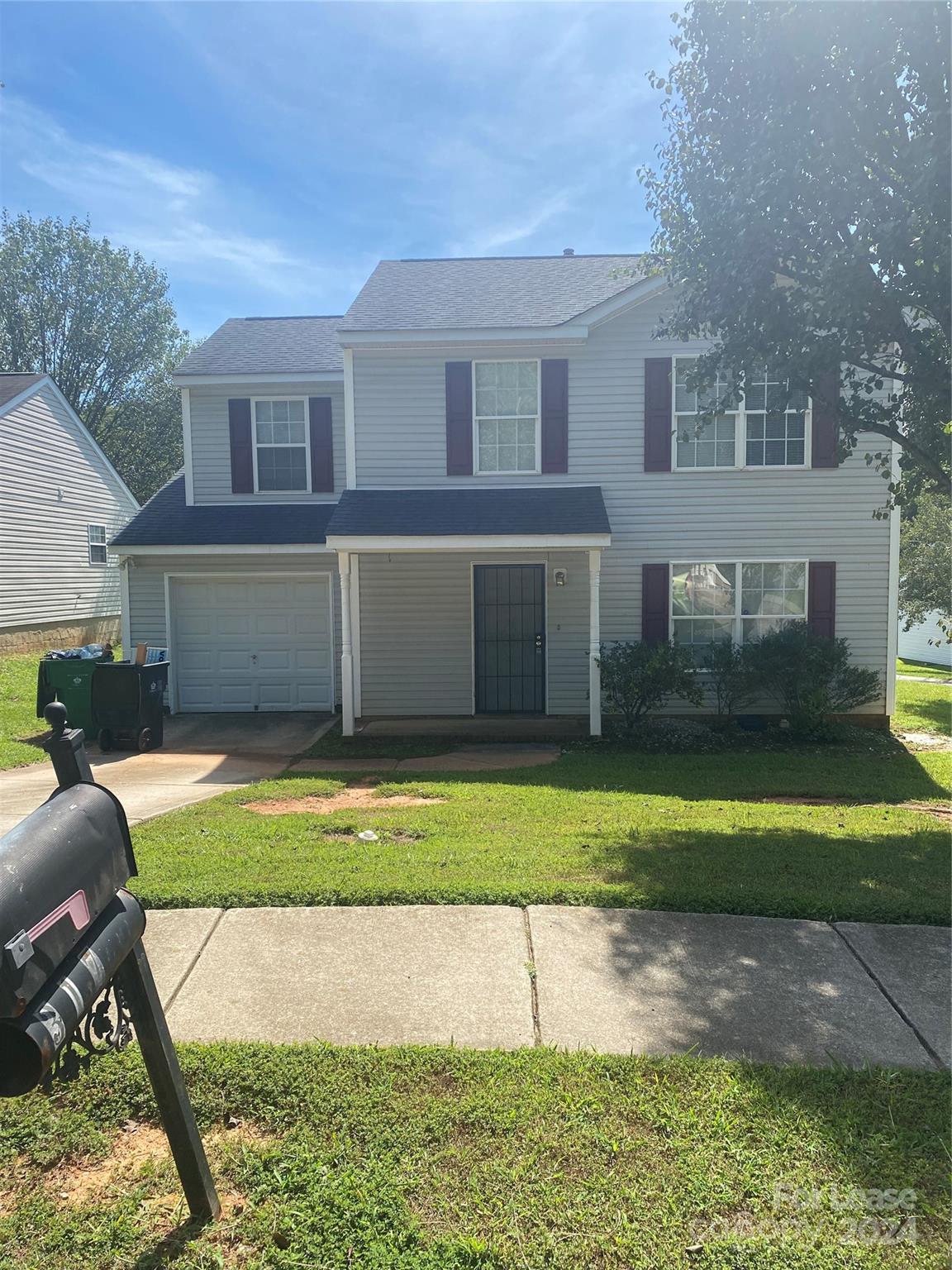 a front view of a house with a yard and a garage