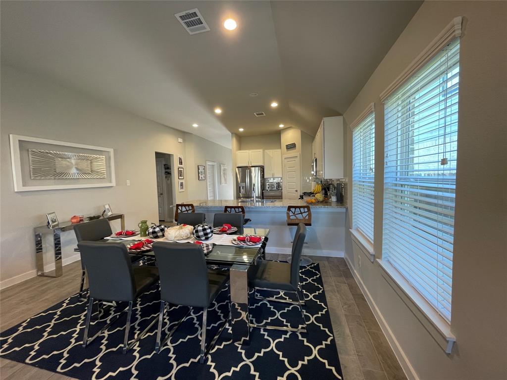 View of the dining room and the open kitchen in this lovely home.