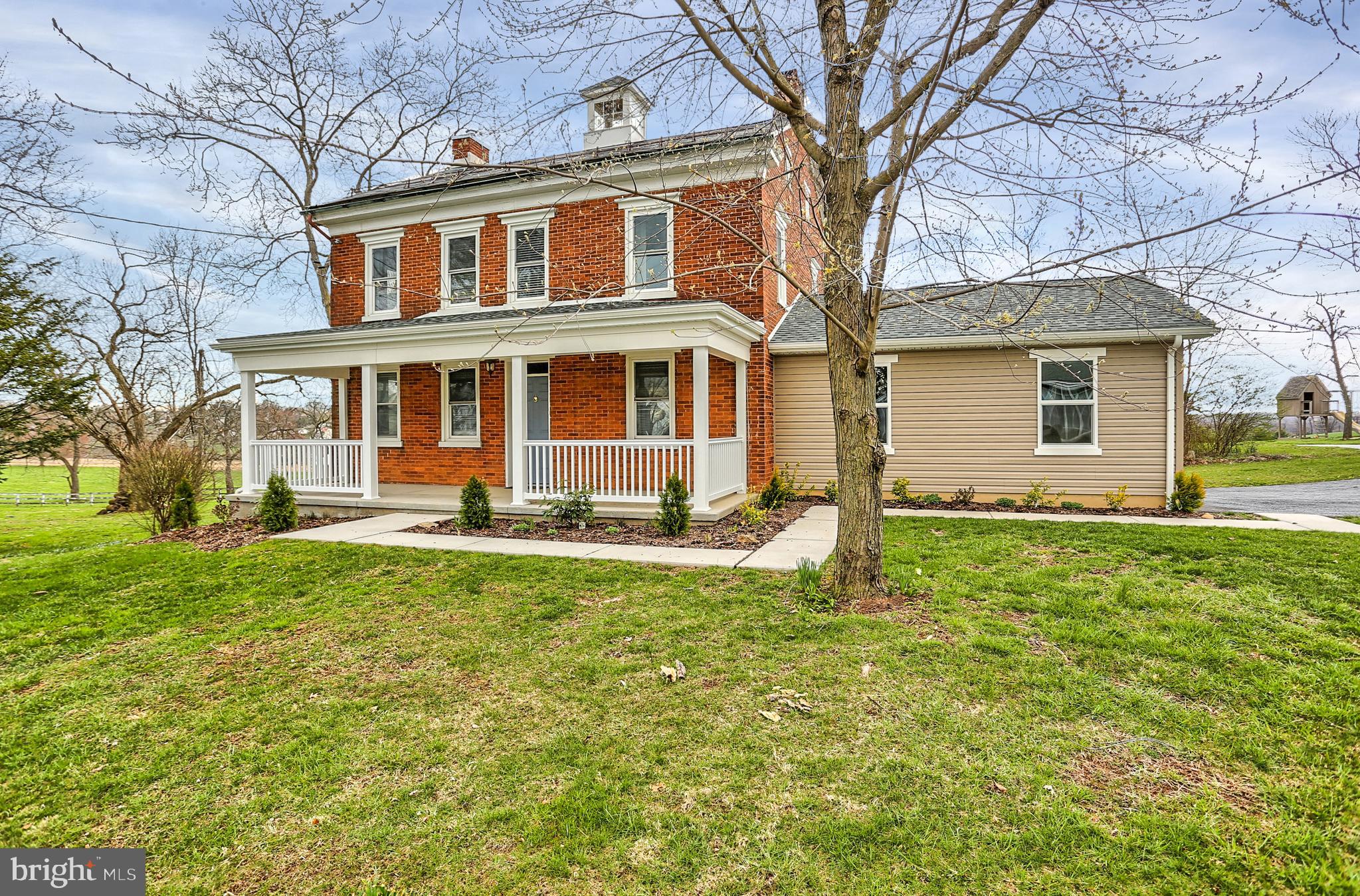 a front view of a house with yard and green space