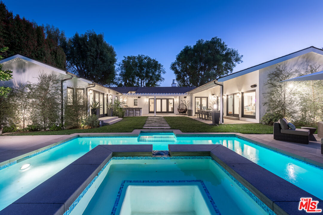 a view of a house with swimming pool and sitting area