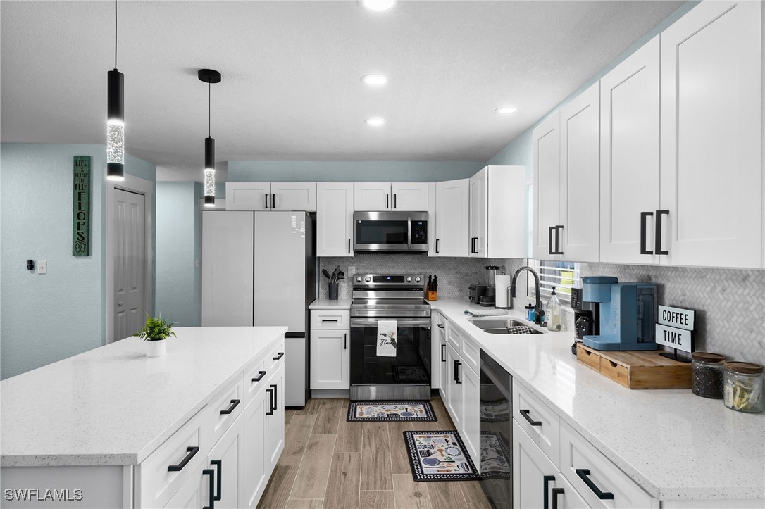 a kitchen with a sink a counter top space stainless steel appliances and cabinets