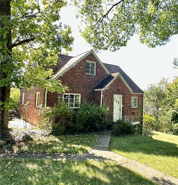 a front view of a house with a yard and trees