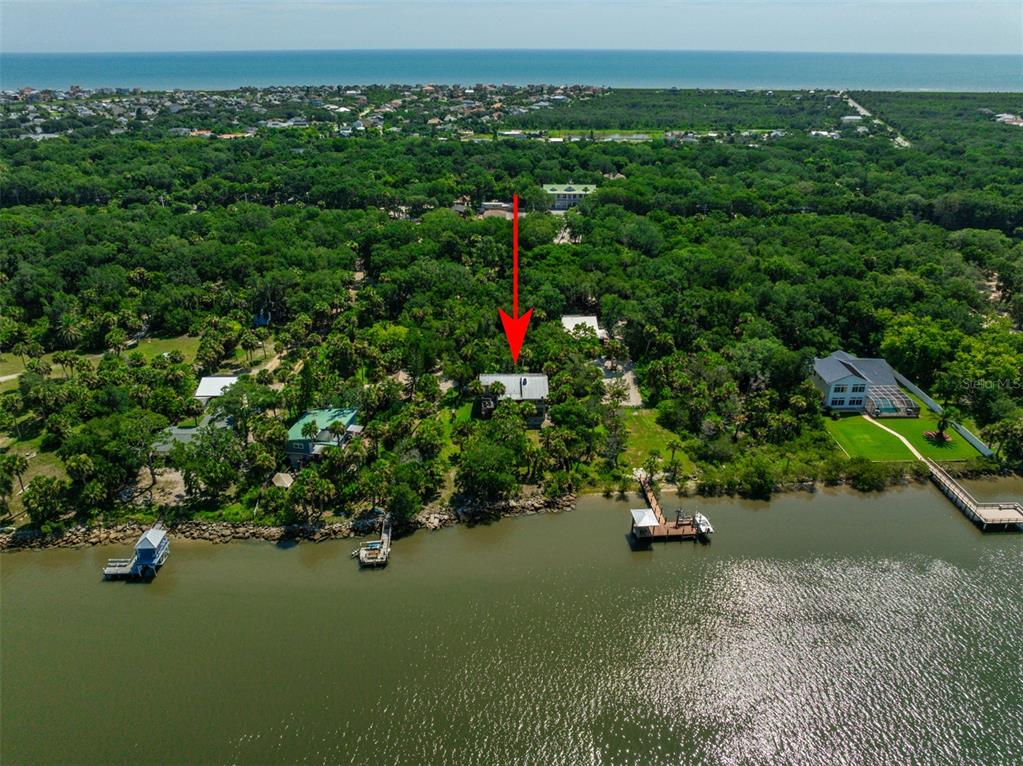 an aerial view of a house with a yard and lake view