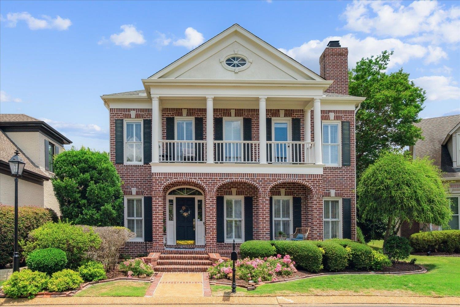 Neoclassical home featuring a balcony