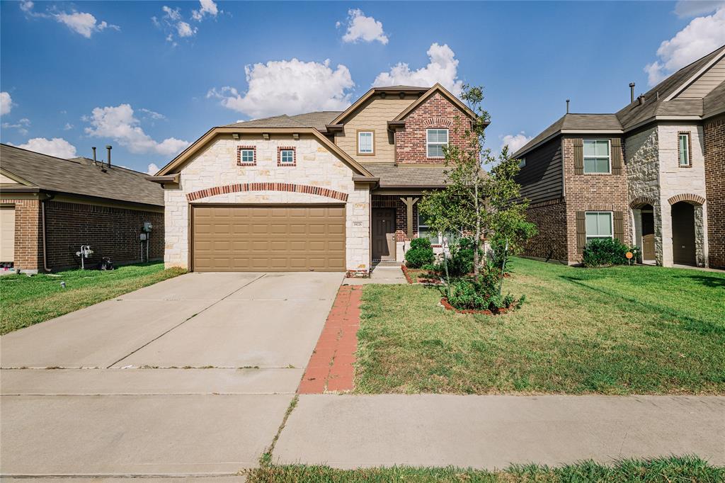 a front view of a house with a yard and garage