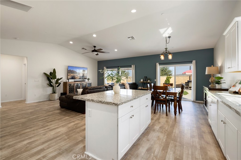 a kitchen with granite countertop a sink appliances and dining table