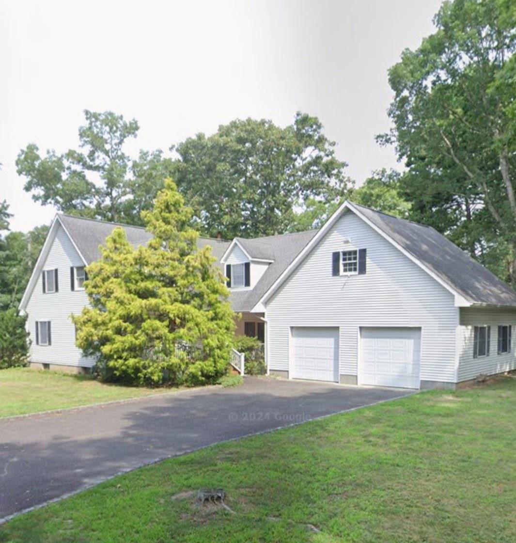 View of front of home with a garage and a front lawn