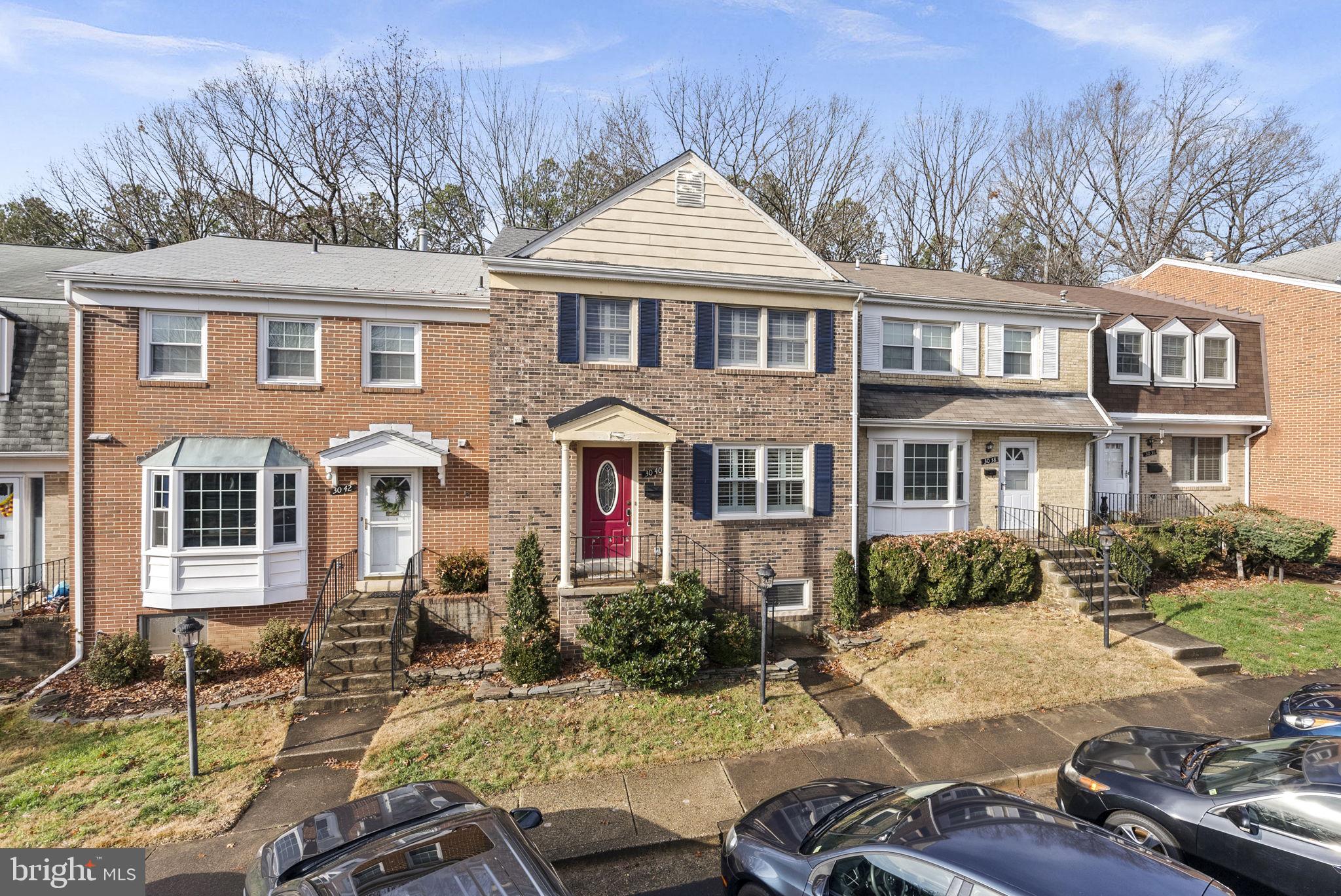 a front view of a house with yard and parking