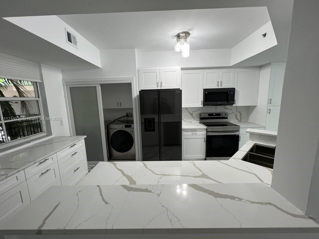 a kitchen with a refrigerator and a stove top oven