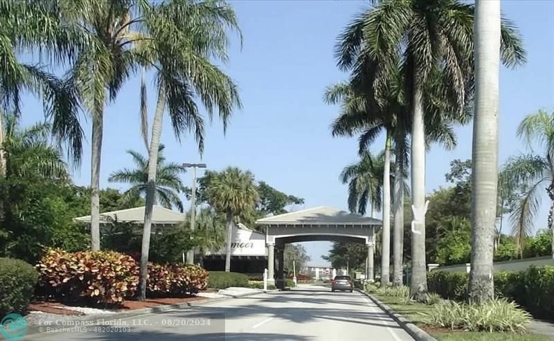 a view of a house with a yard and palm trees