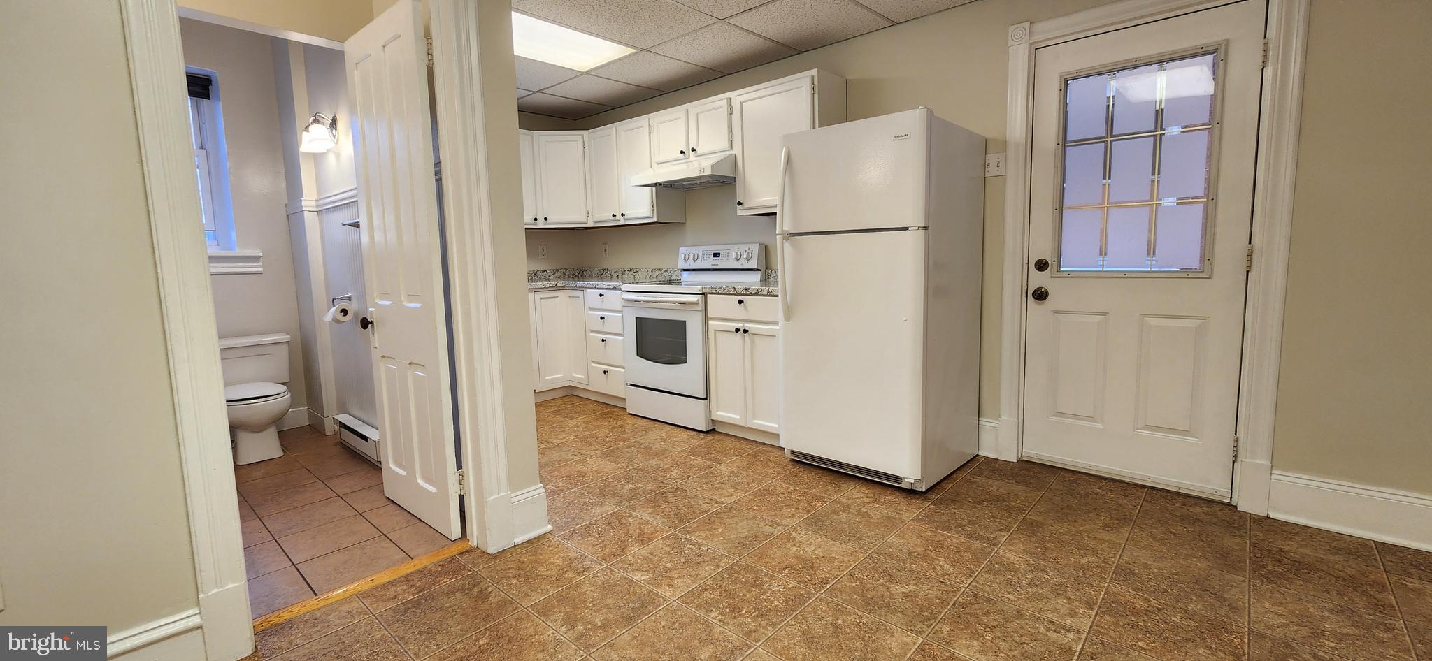 a kitchen with a refrigerator a stove top oven and sink