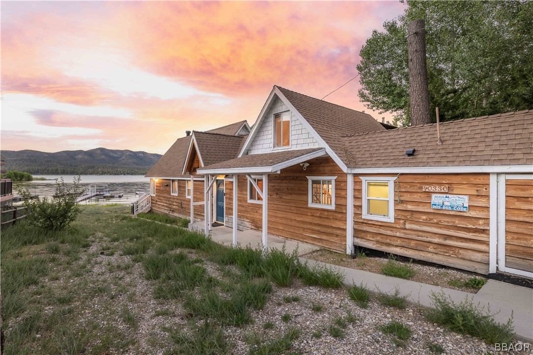 a view of a house with a yard and wooden fence