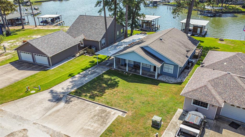 an aerial view of a house with swimming pool and large trees