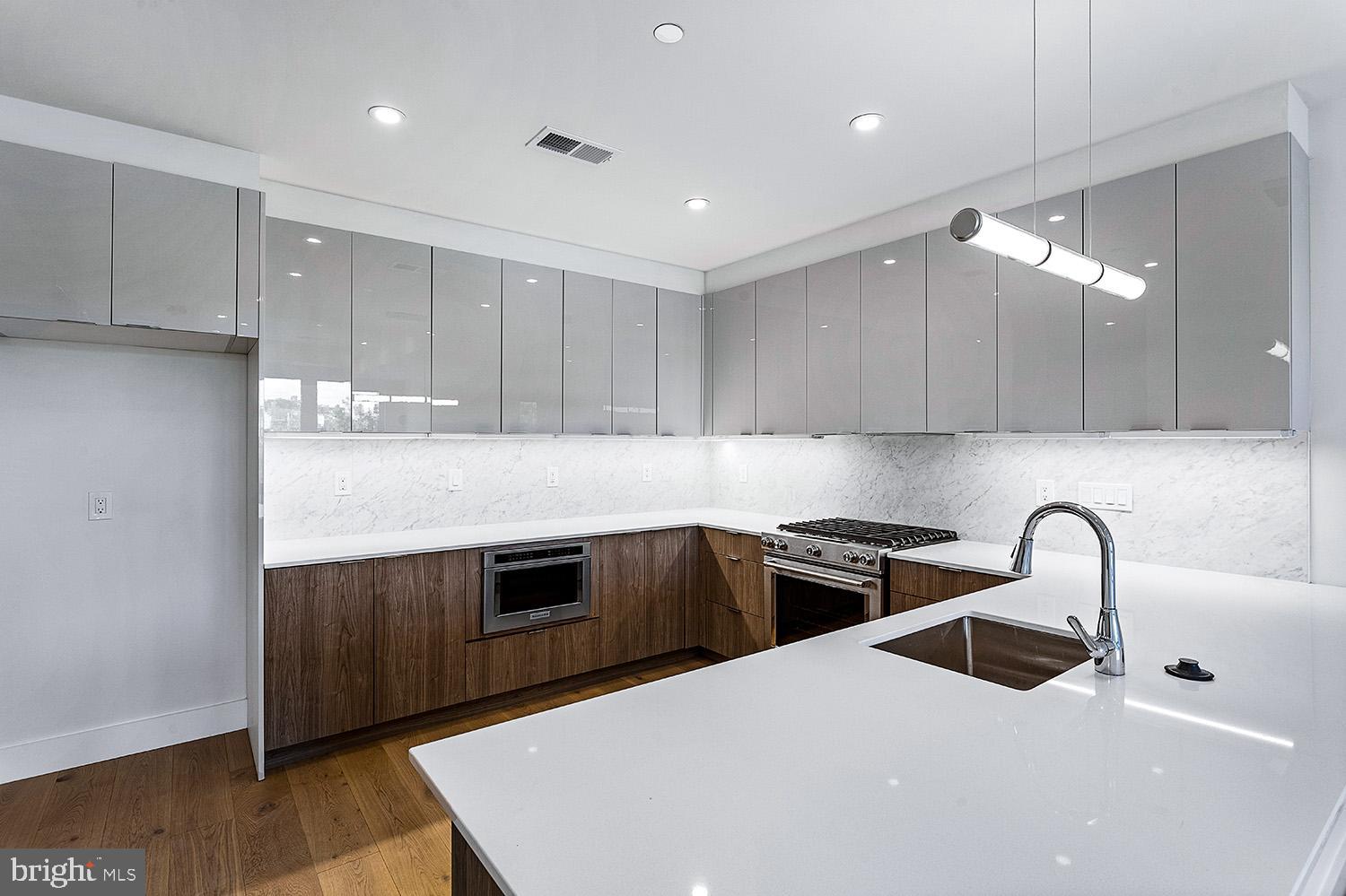 a kitchen with stainless steel appliances a sink a stove a refrigerator and cabinets