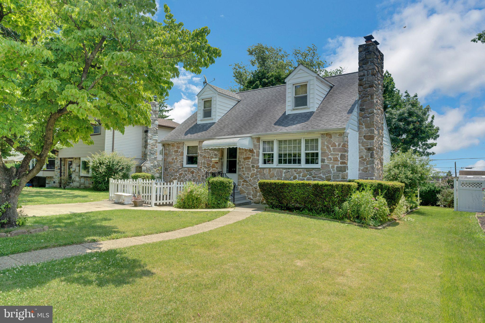 a front view of a house with yard and green space