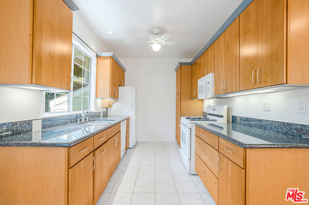 a kitchen with stainless steel appliances granite countertop a sink and a stove