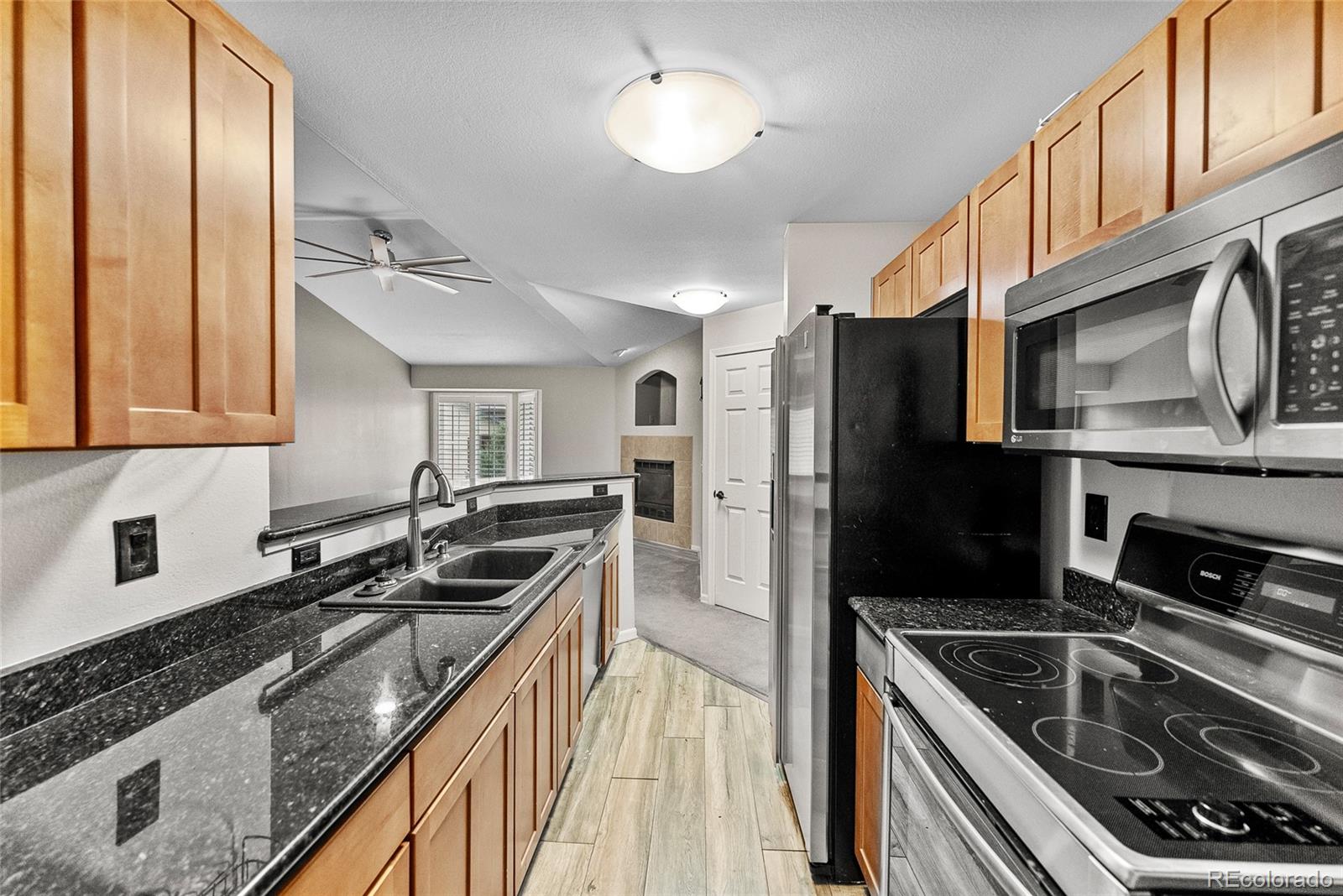 a kitchen with stainless steel appliances granite countertop a stove a sink and a microwave