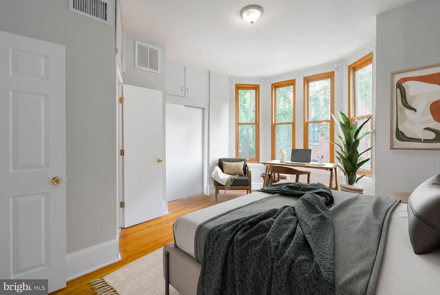 a bedroom with a bed and a large window