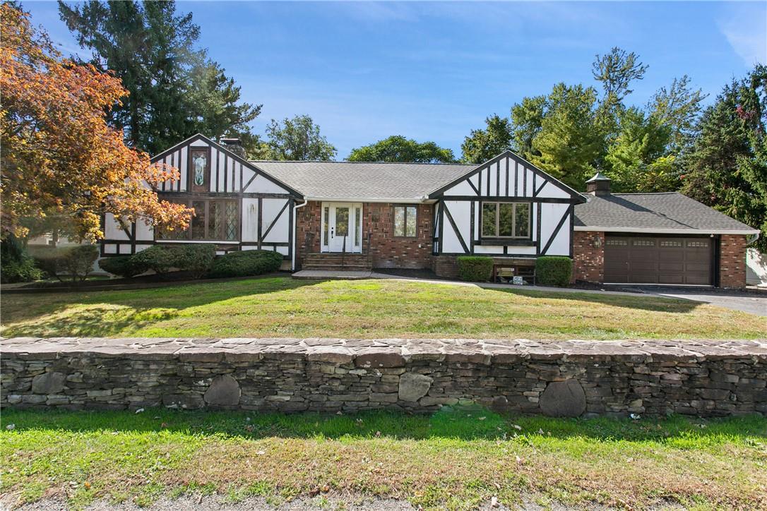 English style home with a front yard and a garage