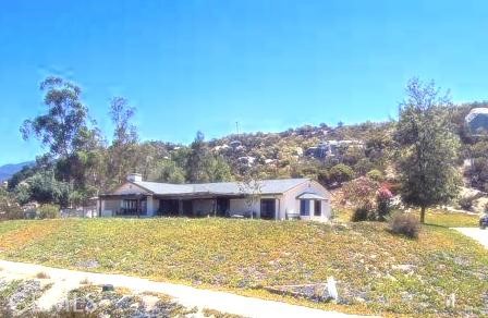 a view of a house with a yard and a large tree