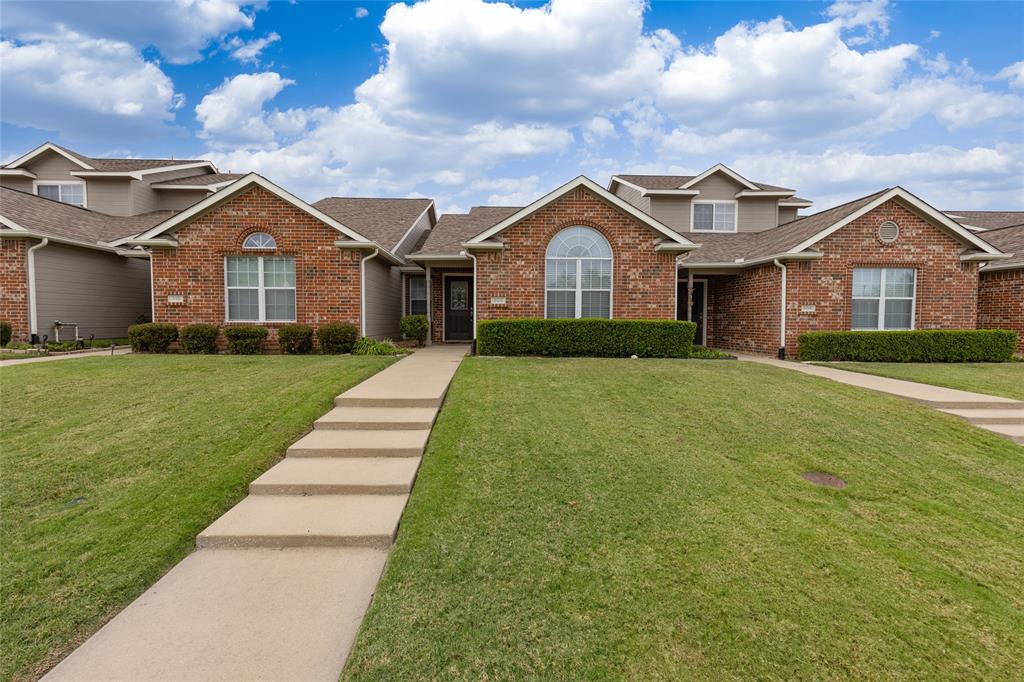 a front view of a house with yard and green space