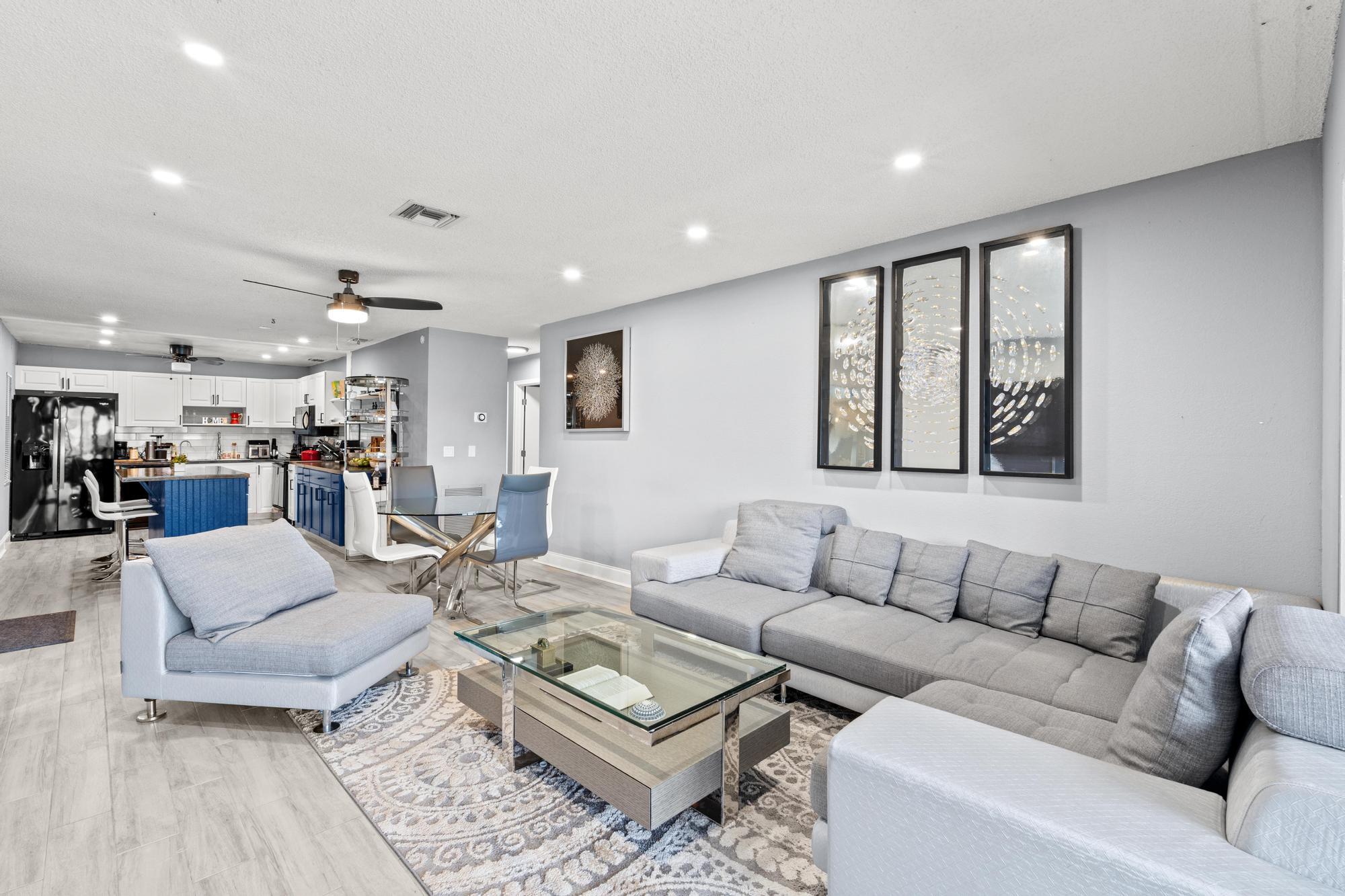 a living room with furniture and view of kitchen