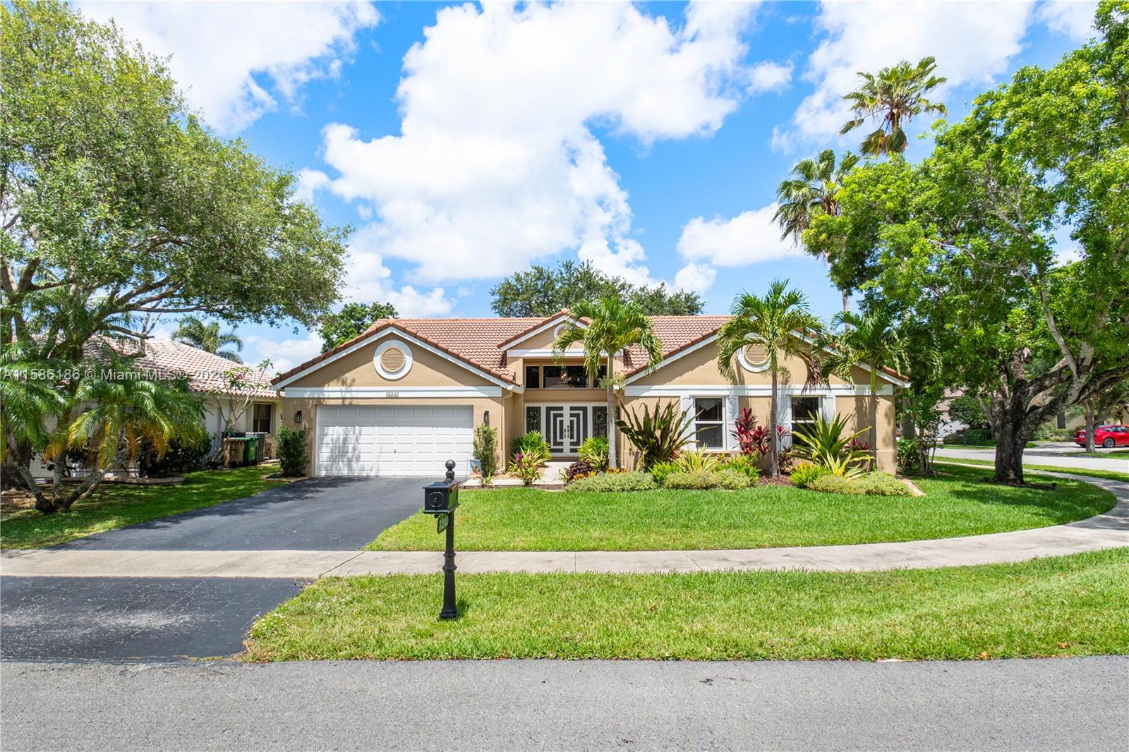 a front view of a house with a yard and trees