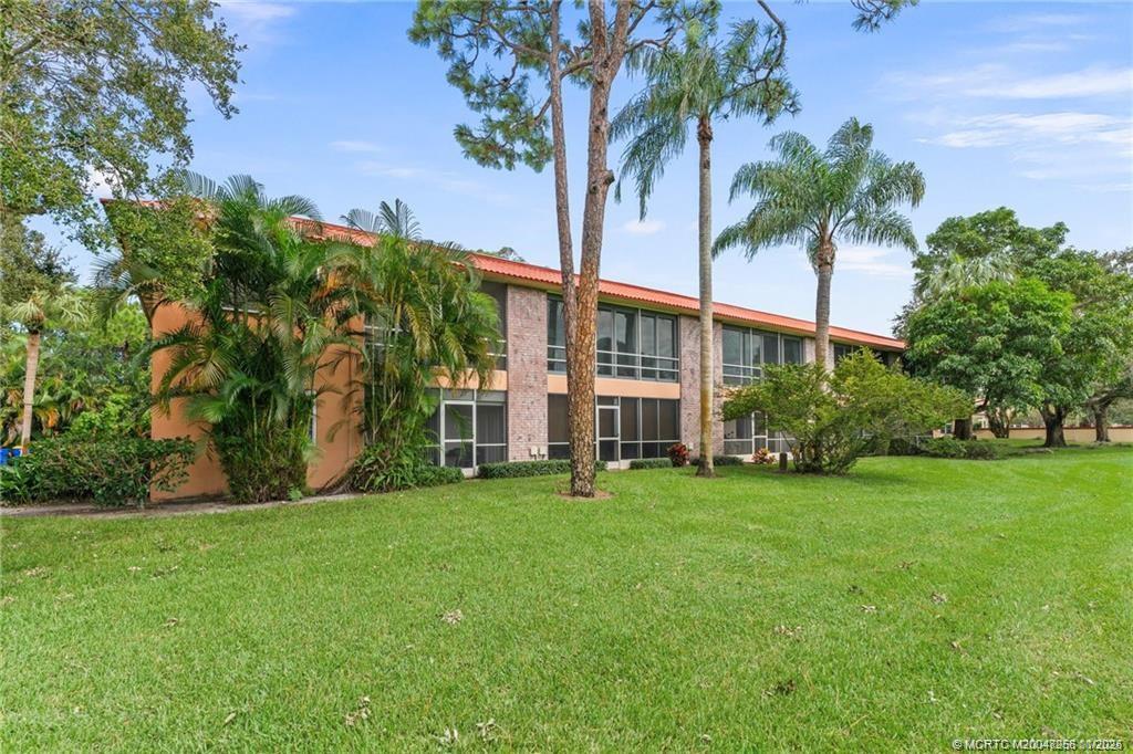 a view of a building with a big yard and palm trees