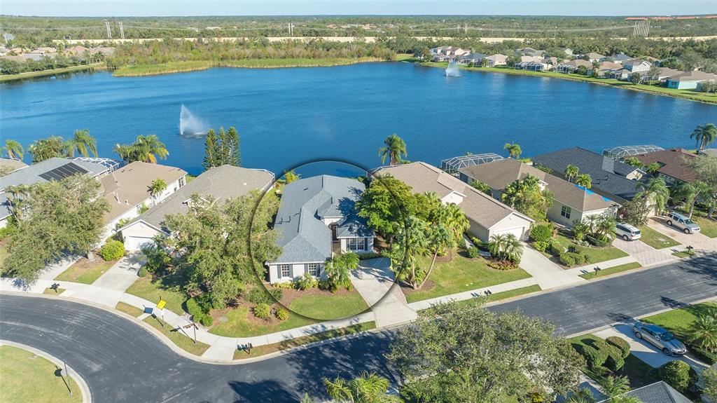 an aerial view of a house with a yard and ocean view