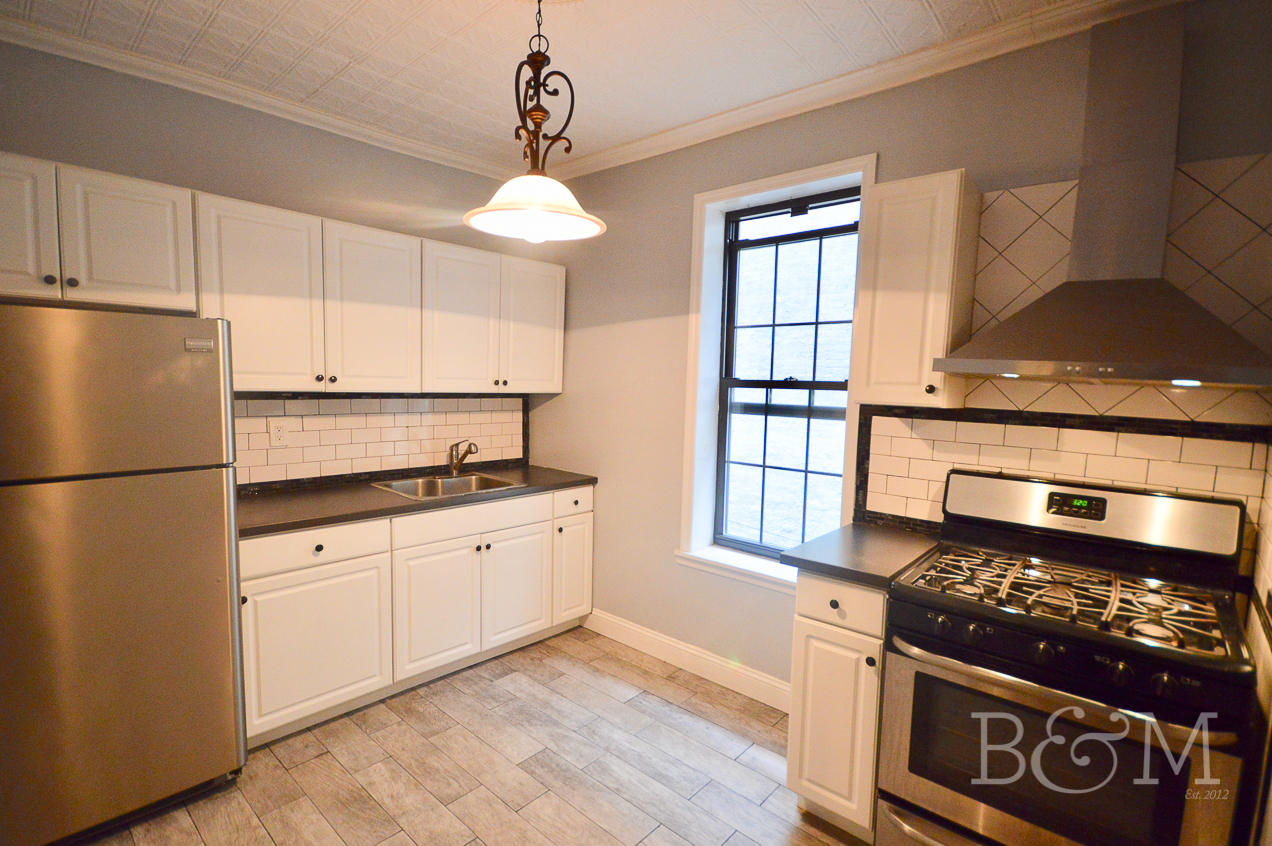 a kitchen with stainless steel appliances granite countertop a stove a sink and a refrigerator