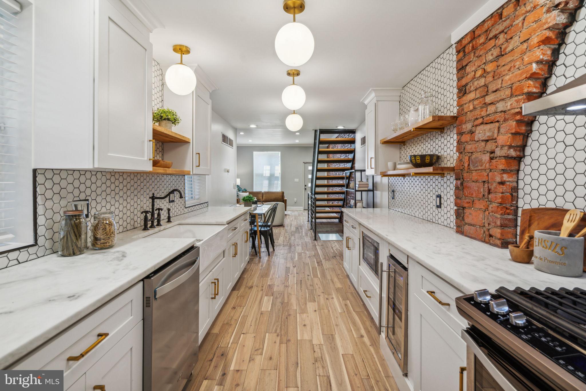 a kitchen with stainless steel appliances granite countertop a stove and a wooden floors