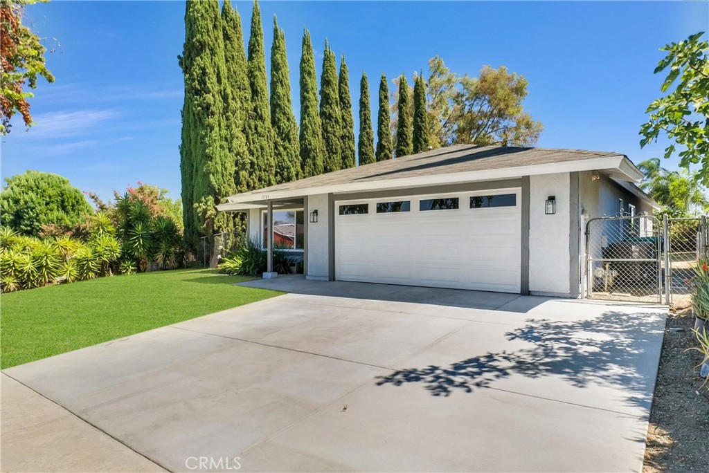 a front view of a house with a yard and trees