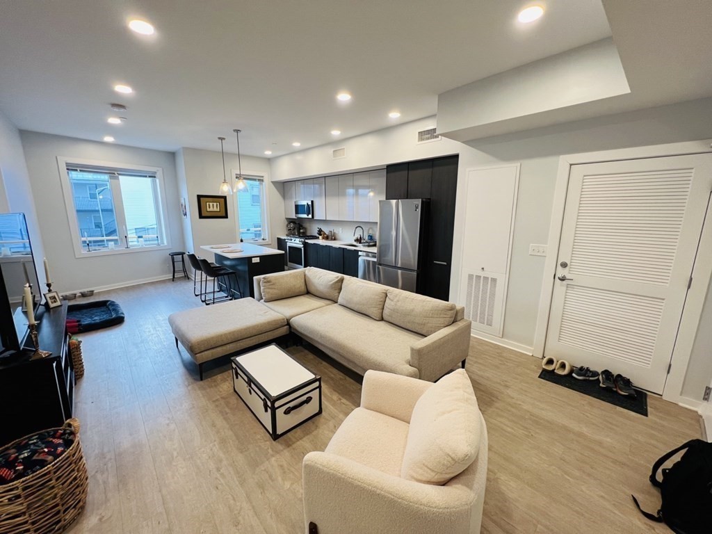 a living room with furniture a flat screen tv and a table