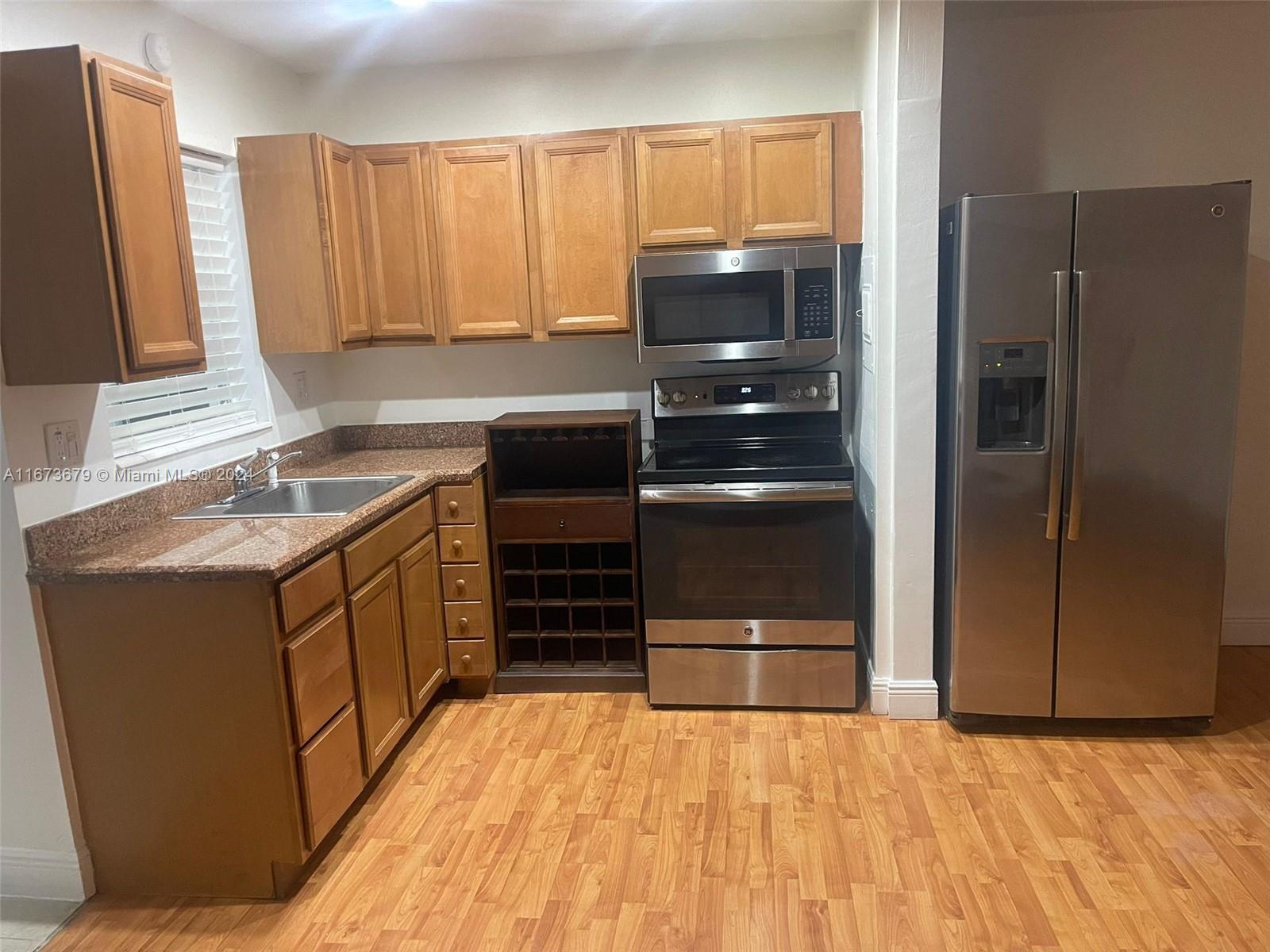 a kitchen with stainless steel appliances a stove a refrigerator and cabinets