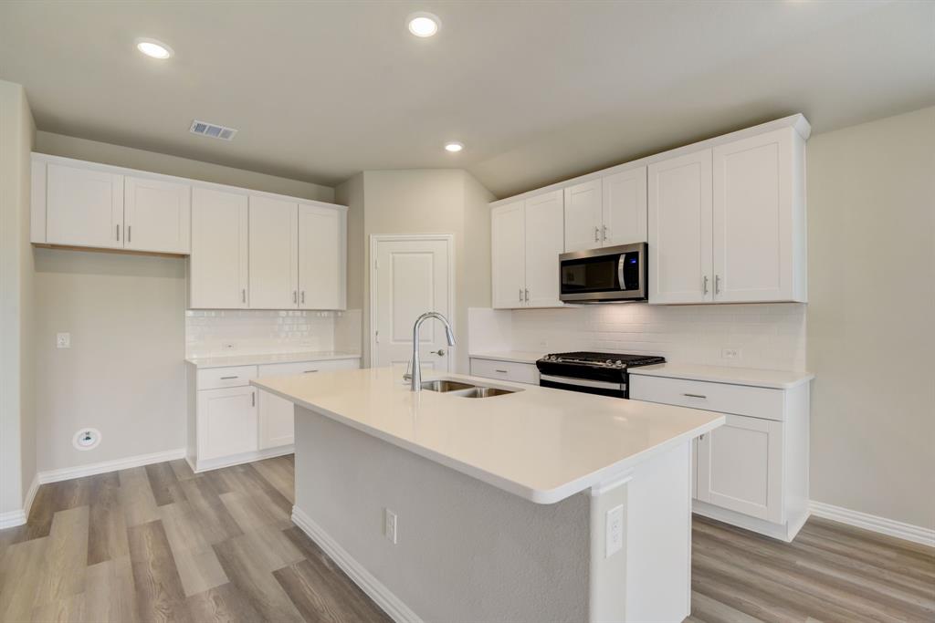 a kitchen with a sink a stove a microwave and cabinets