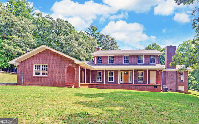 a view of a yard in front of a house with large windows