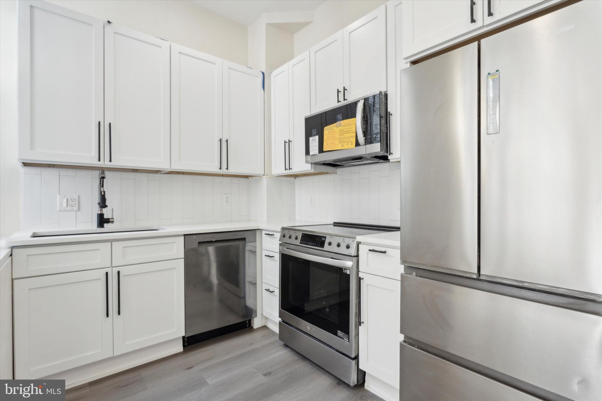 a kitchen with white cabinets and white appliances