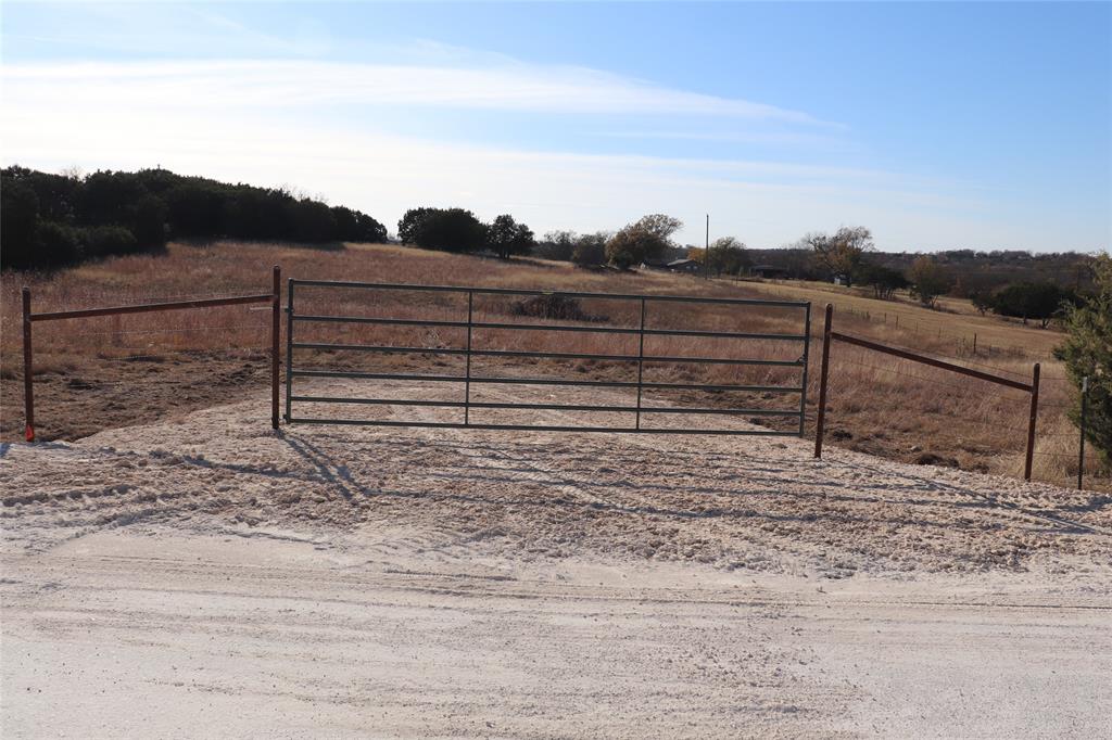 a view of a yard with wooden fence