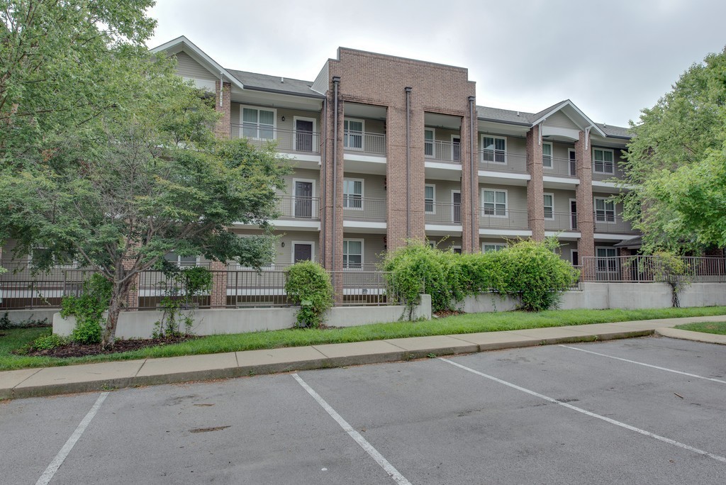 a front view of a residential apartment building with a yard