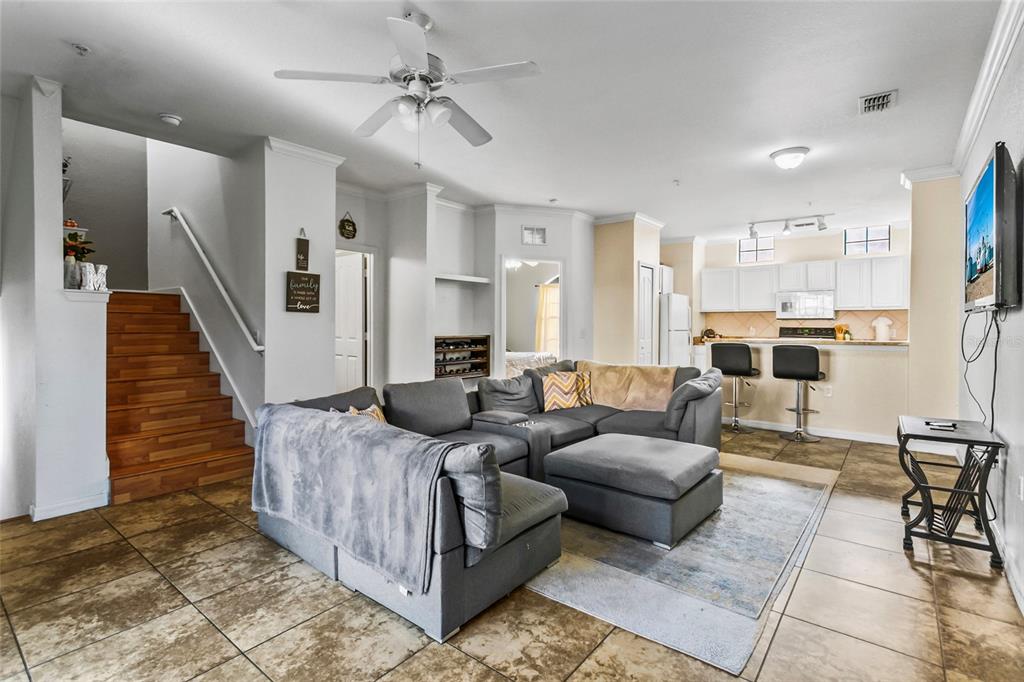 a living room with furniture and a view of kitchen