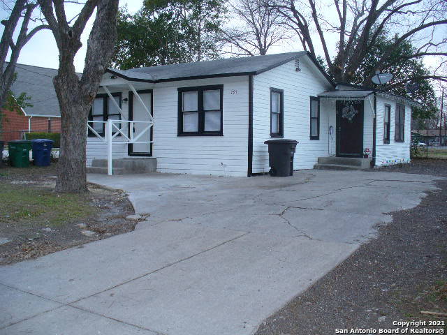 a view of a house with a yard and large tree