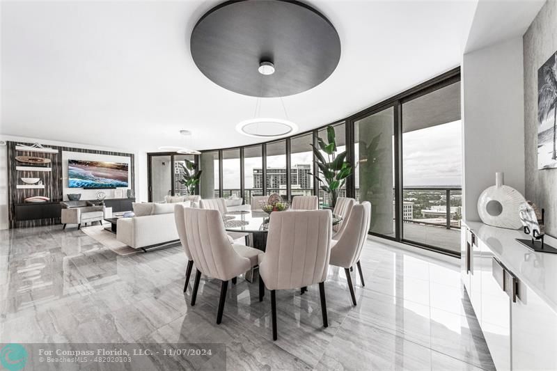 a dining room with furniture and a floor to ceiling window