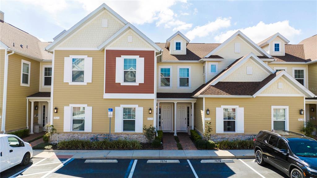 a front view of a house with yard and parking