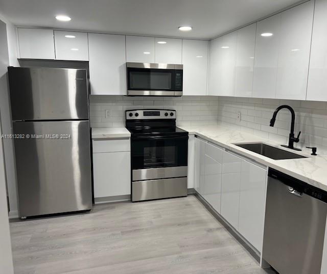 a kitchen with a refrigerator sink and wooden cabinets