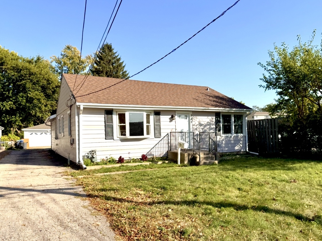 a front view of a house with a yard outdoor seating and garage